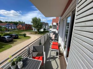 Großer Balkon mit Tisch und Liegestühlen